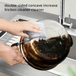 Manos limpiando sartén con paño de fibra metálica en fregadero, eliminando grasa carbonizada.