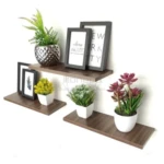 Kit repisa flotante madera aglomerada de tres medidas, con plantas, marcos y macetas organizadas en pared.