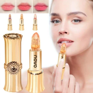 Labial brillo cristal con colágeno, color cambiante y acabado brillante. Presentación en tubo dorado con detalles ornamentales, incluye muestra de aplicación en labios y tres tonos disponibles.