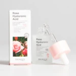 Serum Bioaqua Rosa y Ácido Hialurónico con gotero, envase transparente y caja con de rosas.