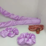 Set de dos onduladores de pelo con cerámica en color lila, acompañados de dos diademas del mismo tono y un peine de dientes anchos en color rojizo, dispuestos sobre fondo blanco.