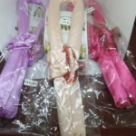 Tres onduladores de pelo enrollados en plástico transparente, en tonos lavanda, crema y fucsia, con diadema incluida.