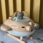 Humificador de aire en forma de nave espacial, color beige y blanco, con cúpula transparente y detalles metálicos, sobre superficie de mármol.