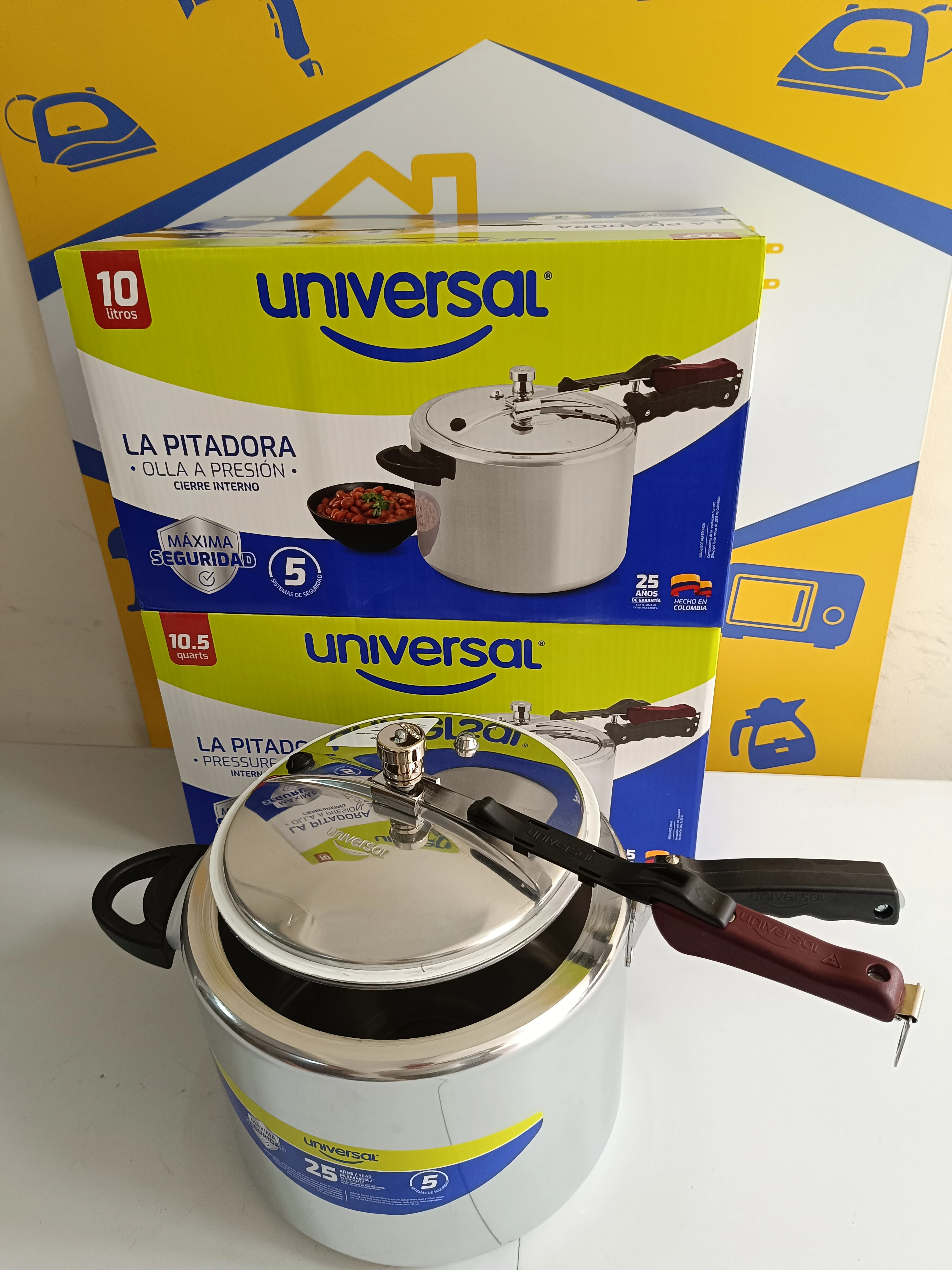 Olla a presión de aluminio Universal de 10 litros, con tapa metálica y mango negro, sobre caja original que muestra del producto y detalles de seguridad reforzada.