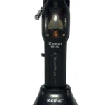Afeitadora eléctrica Kemei KM-1763 en color negro, con base de carga y peines ajustables visibles. Diseño compacto para corte de barba y patillas.