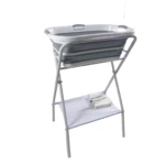 Soporte bañera ballena con base metálica plegable, color gris claro, incluye estante inferior con toalla y botella.