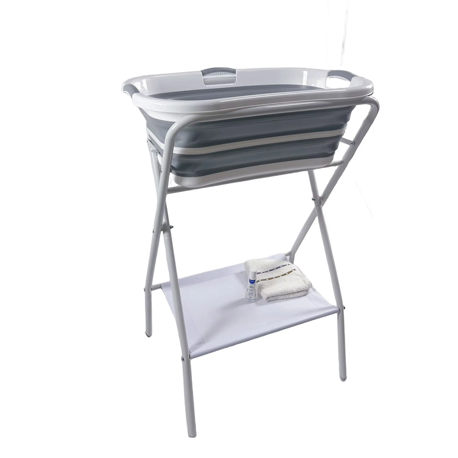 Soporte bañera ballena con base metálica plegable, color gris claro, incluye estante inferior con toalla y botella.