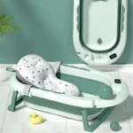 Bañera plegable para bebé con soporte en forma de ballena, color verde menta y blanco, con base metálica y accesorios incluidos.