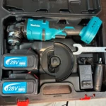 Kit de pulidora inalámbrica Makita 128V brushless en estuche negro, incluye dos baterías de 5.0Ah, cargador, disco de corte y llave, todo visible en disposición ordenada.