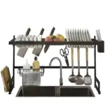 Escurridor de vajilla negro mate con estantes superiores para cuchillos y platos, soporte lateral para utensilios y cestas inferiores para jabón y trapo, instalado sobre fregadero de dos cuencos.