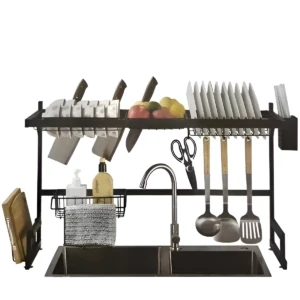 Escurridor de vajilla negro mate con estantes superiores para cuchillos y platos, soporte lateral para utensilios y cestas inferiores para jabón y trapo, instalado sobre fregadero de dos cuencos.