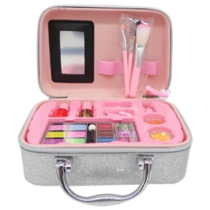 Maletín escarchado plateado con asa metálica, interior rosa que contiene espejo, pinceles, brochas, paleta de colores y recipientes con pigmentos.