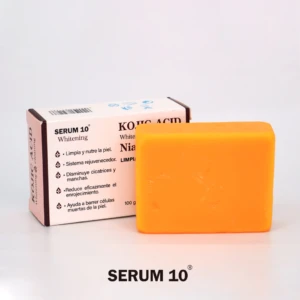 Jabón despigme Kojic X2 con Niacinamida, barra amarilla naranja junto a su empaque blanco con texto informativo.