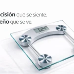 Báscula de baño cuadrada de cristal templado con display digital mostrando 62.4 kg y cuatro sensores metálicos en las esquinas.