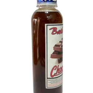 Botella de gel corporal de chocolate en presentación transparente con etiqueta blanca y tapa azul, mostrando textura viscosa y trozos de chocolate en la .