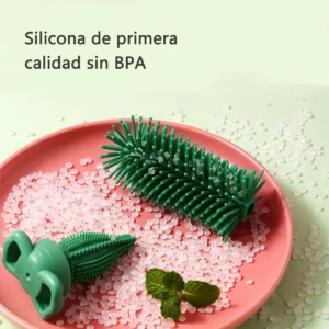 Cepillo de silicona verde para limpiar biberones, con cerdas flexibles y mango ergonómico, sobre plato rosa con gránulos blancos y hojas de menta.