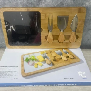Tabla de queso cuadrada de madera con herramientas incluidas, mostrada en su caja de presentación.