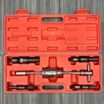 Caja naranja abierta con extractor de rodamientos interno de 5 piezas, incluyendo herramienta principal y accesorios, sobre superficie gris texturizada.