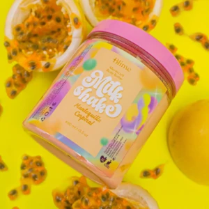 Contenedor de mantequilla corporal Blime de 400 ml, con tapa rosa y etiqueta multicolor, rodeado de frutos de maracuyá sobre fondo amarillo vibrante.