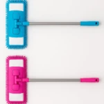 Dos traperos de microfibra con varilla de acero de 1 metro, uno en azul y otro en rosa, diseñados para limpiar esquinas y rincones difíciles.