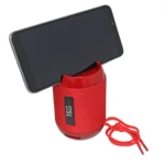 Bocina roja con soporte para celular, mostrando dispositivo negro insertado en su ranura superior y correa de transporte roja colgando lateralmente.