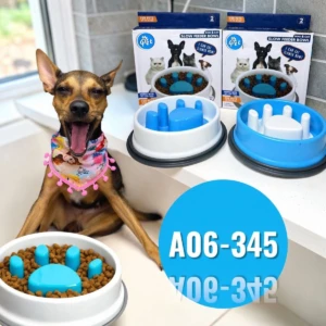Comedero antirreflujo para perros y gatos, modelo A06-345, con diseño de huella azul y base blanca, acompañado de su variante en azul sólido, ambos sobre superficie blanca con perro al fondo.