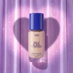 Base de maquillaje Pantera Celeste en presentación de 30 ml, con tapa azul y etiqueta que indica acabado mate y larga duración, sobre fondo lila con forma de corazón.