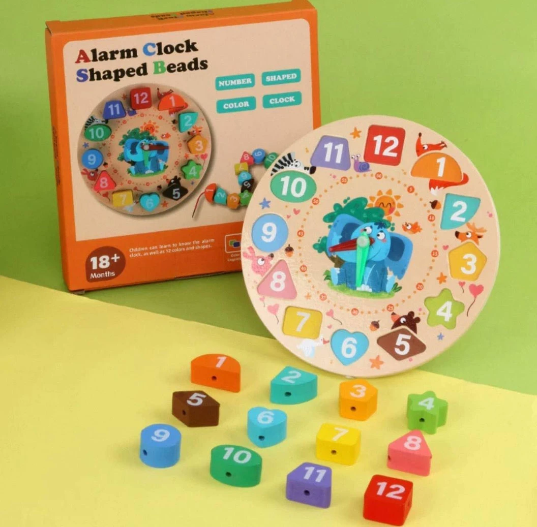 Reloj educativo de madera con bloques numerados y formas, caja naranja y piezas dispersas sobre fondo amarillo.