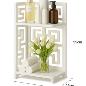 Estante esquinero blanco de dos niveles con diseño geométrico, iluminado por luz LED integrada. Mide 55 cm de alto y 22 cm de ancho por profundidad. Incluye repisas con objetos decorativos como flores, botellas y rollos de toalla.