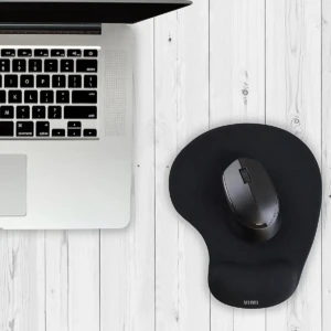 Mouse ergonómico negro con almohadilla de gel, sobre base curva en color negro, junto a laptop plateada sobre superficie de madera blanca.