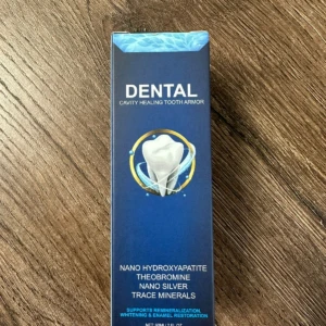 Caja azul del suero dental con nanohidroxiapatita, mostrando diente blanco en círculo dorado y lista de ingredientes en etiqueta frontal.