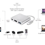 Adaptador USB 3.1 tipo C en color plateado con múltiples puertos HDMI, USB y carga simultánea para laptop, monitor, teclado y mouse.
