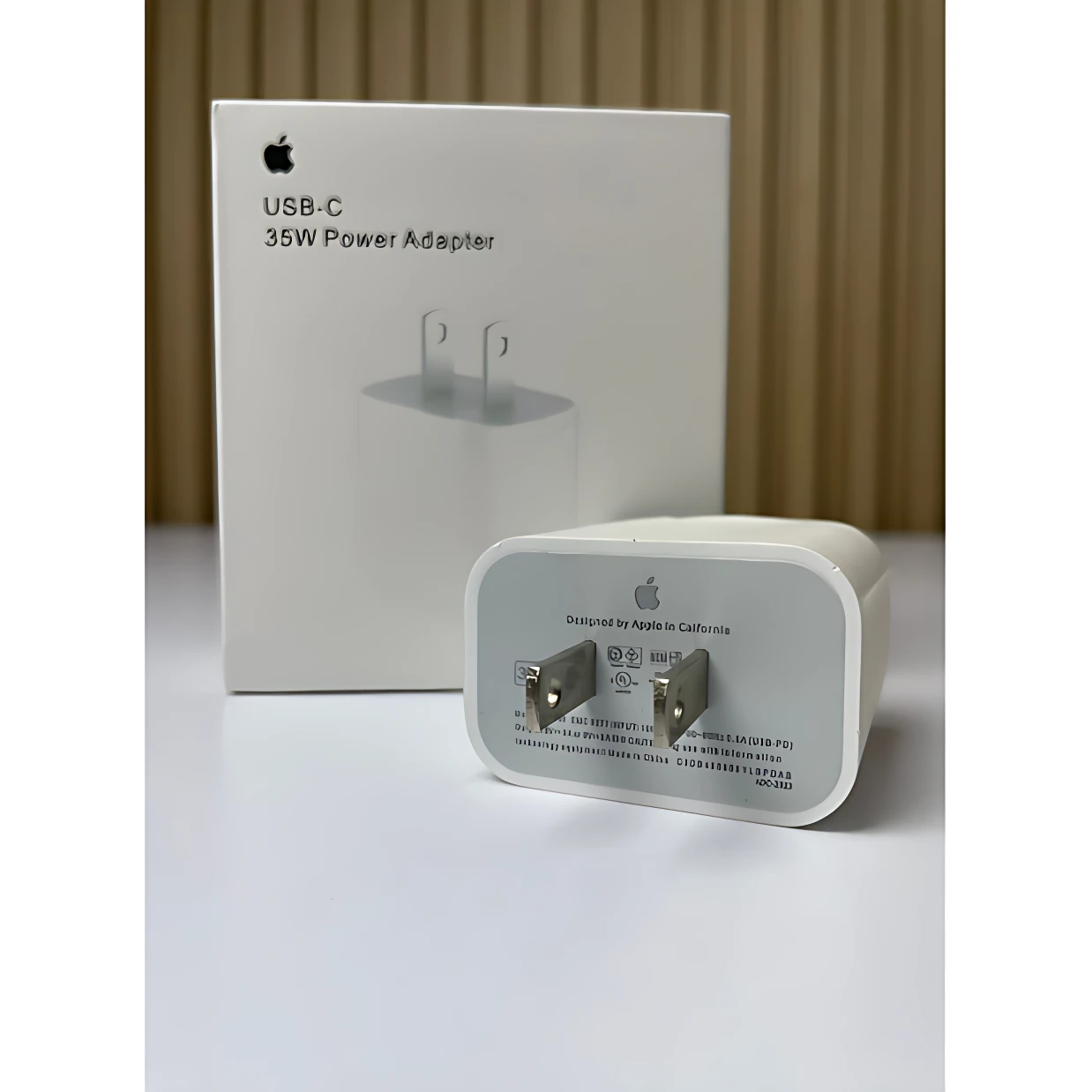 Adaptador USB-C 35W de Apple, color blanco, con enchufe tipo A y caja original al fondo.