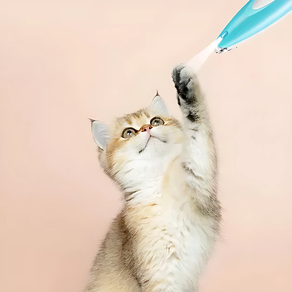 Afeitadora inalámbrica LED azul claro en uso sobre gato de pelaje claro, con luz frontal encendida y fondo rosa pálido.