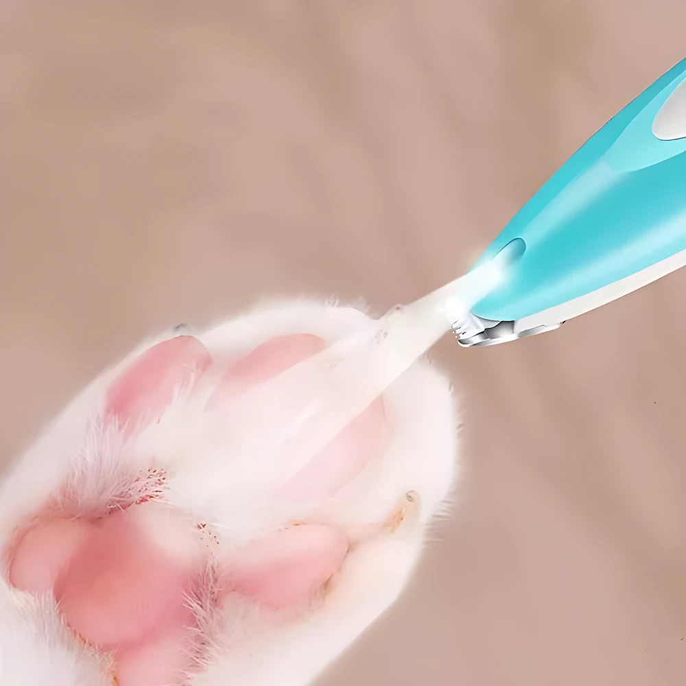 Afeitadora inalámbrica LED azul recortando pelaje en patita de gato, con luz visible en la zona de corte.