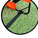 Detalle de la base de la portería de microfútbol plegable con varillas de fibra de vidrio, mostrando su sistema de anclaje con correa negra sobre césped artificial verde.