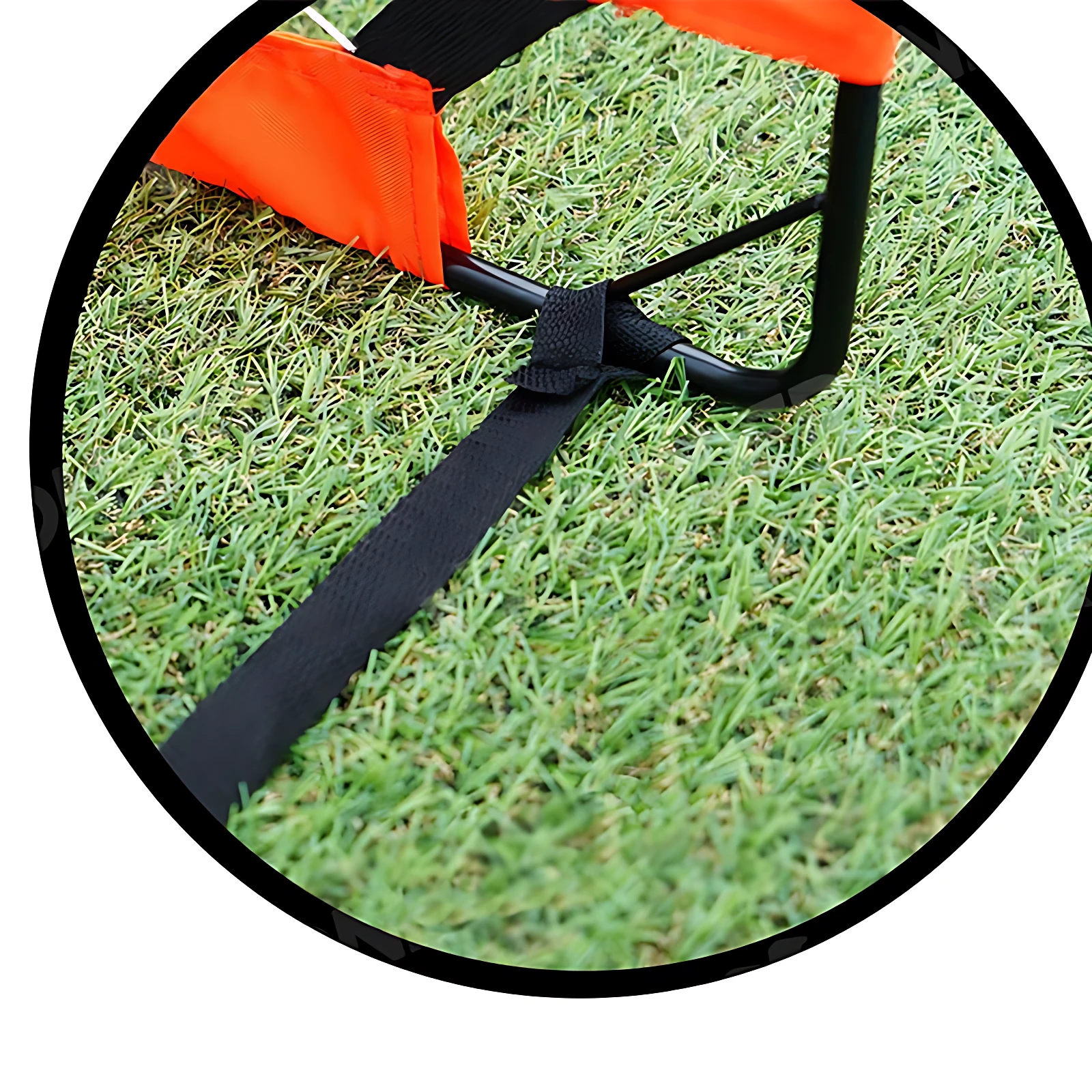 Detalle de la base de la portería de microfútbol plegable con varillas de fibra de vidrio, mostrando su sistema de anclaje con correa negra sobre césped artificial verde.