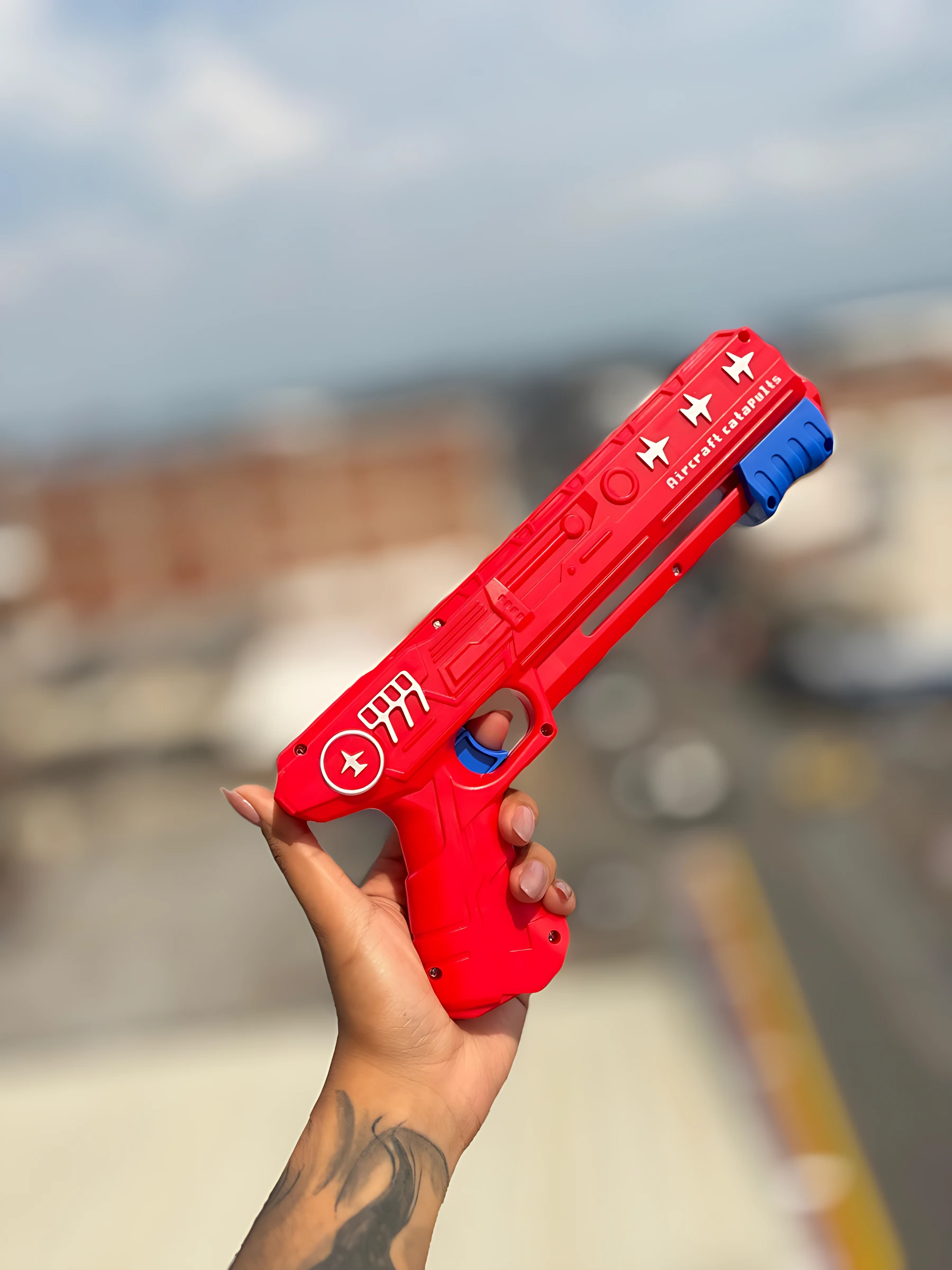 Pistola de carga rápida roja con detalles en azul, sostenida en mano, mostrando logotipo y texto "T800A" en cuerpo.