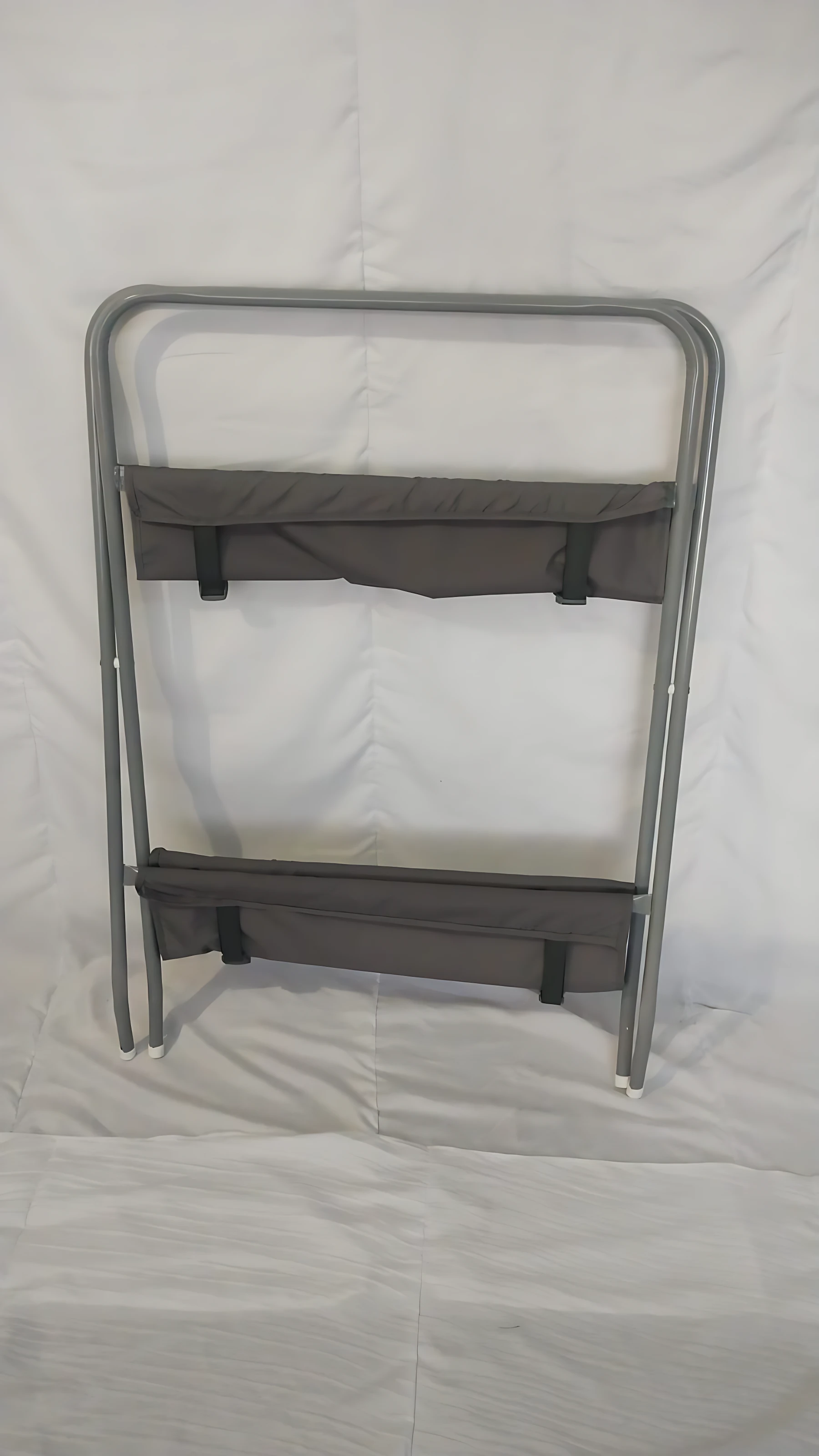 Soporte bañera ballena plegable con base metálica y dos estantes de tela gris para almacenamiento.