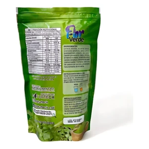 Saco verde de 200g del batido Fibro Verde, con etiqueta mostrando información nutricional, ingredientes y instrucciones de uso. Incluye de vegetales frescos y vaso con bebida verde.