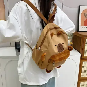 Mochila beige con diseño de capibara de peluche, vista trasera sobre modelo con camiseta blanca.