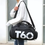Bolso deportivo negro con logo T60 en blanco, asa superior y correa ajustable, usado por mujer con ropa casual.