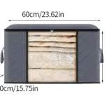 Caja de almacenamiento rígida gris con visor, de 60 cm de ancho, 35 cm de alto y 40 cm de profundidad, mostrando sábanas enrolladas dentro.