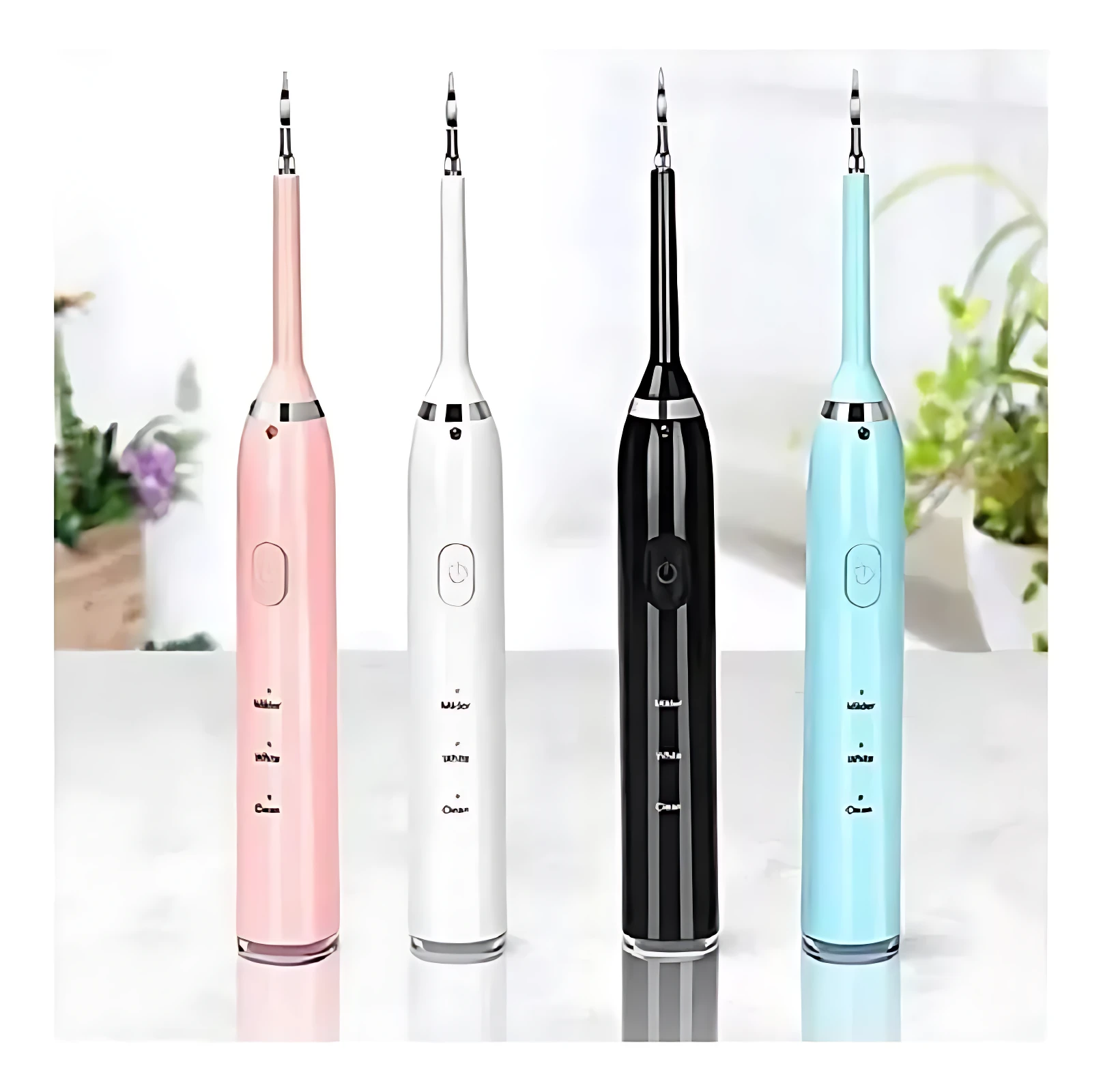 Cuatro cepillos ultrasónicos para limpieza facial en rosa, blanco, negro y azul claro, con cabezales intercambiables y botones centrales, sobre superficie blanca con plantas de fondo.