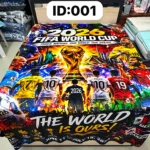 Cobija digitalizada con diseño de Copa Mundial FIFA 2026, mostrando jugadores y trofeo en colores vibrantes sobre fondo oscuro, con texto "THE WORLD IS OURS" en la parte inferior.