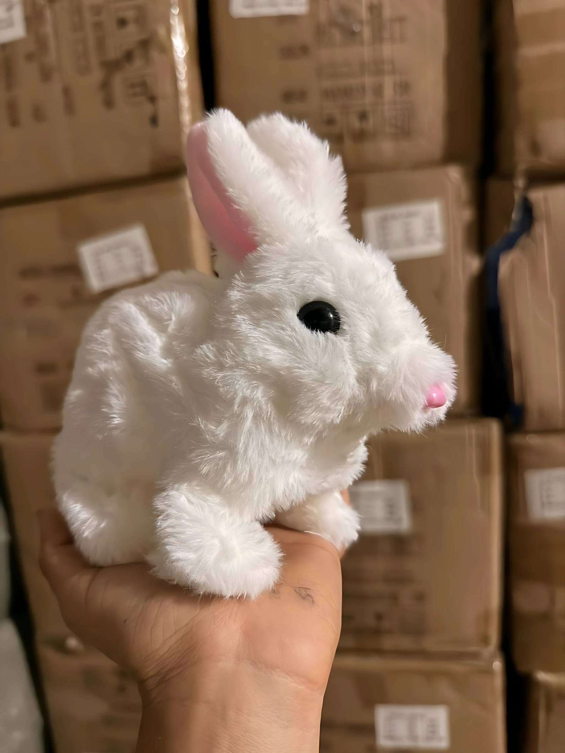 Peluche conejo blanco de pelaje suave, orejas rosadas y nariz rosa, sostenido en la mano; variante individual del set de tres.