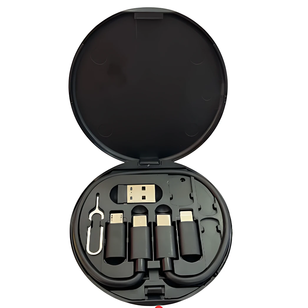 Caja redonda negra abierta mostrando cuatro adaptadores USB tipo C y uno tipo A, junto con una herramienta de apertura, organizados en compartimentos individuales.