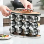 Organizador de especias con 12 frascos de vidrio y base de madera, con asa metálica y tapa superior, sobre encimera blanca.