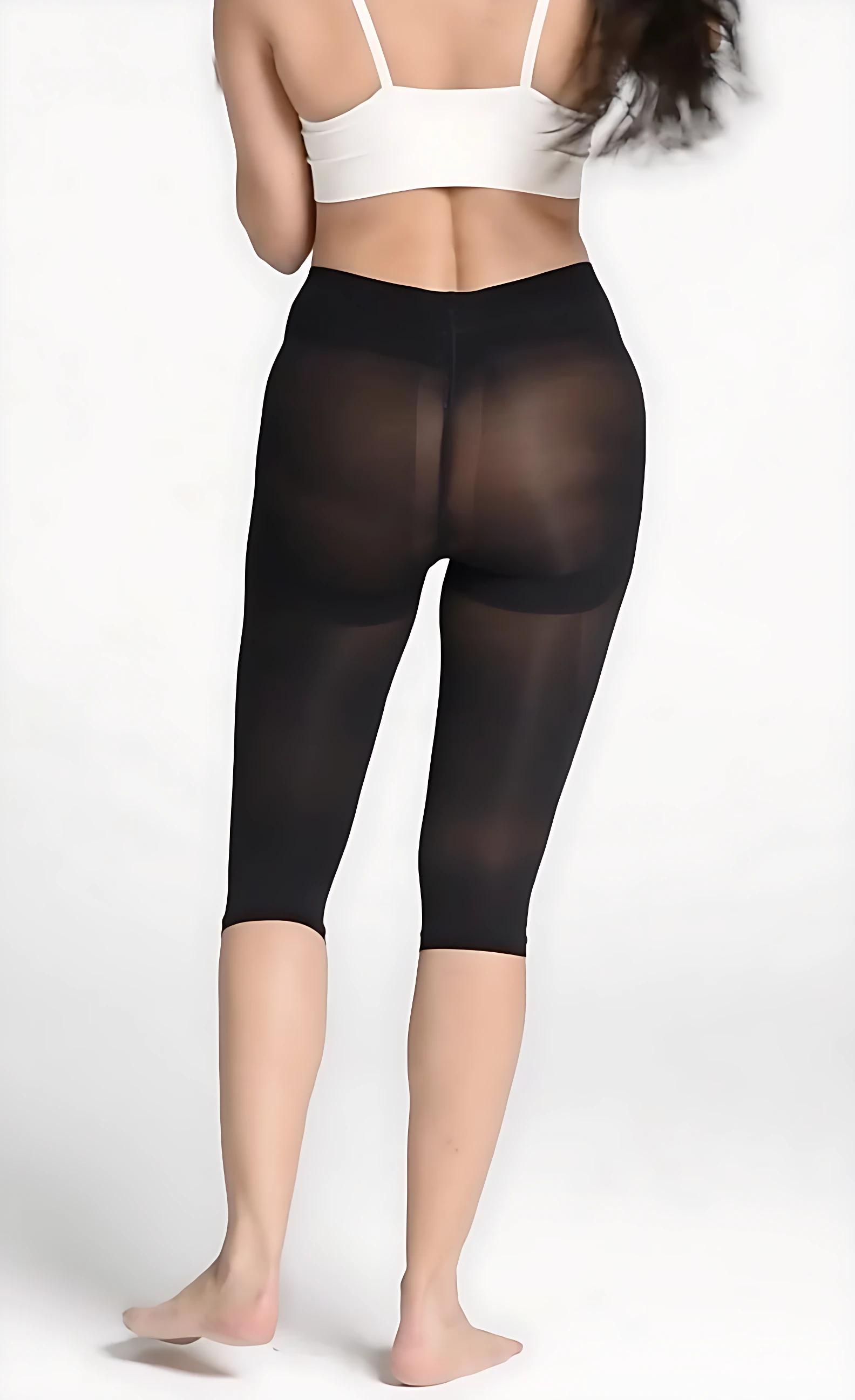 Vista posterior de faja moldeadora capri negra con levantador de glúteos, sobre top blanco deportivo.
