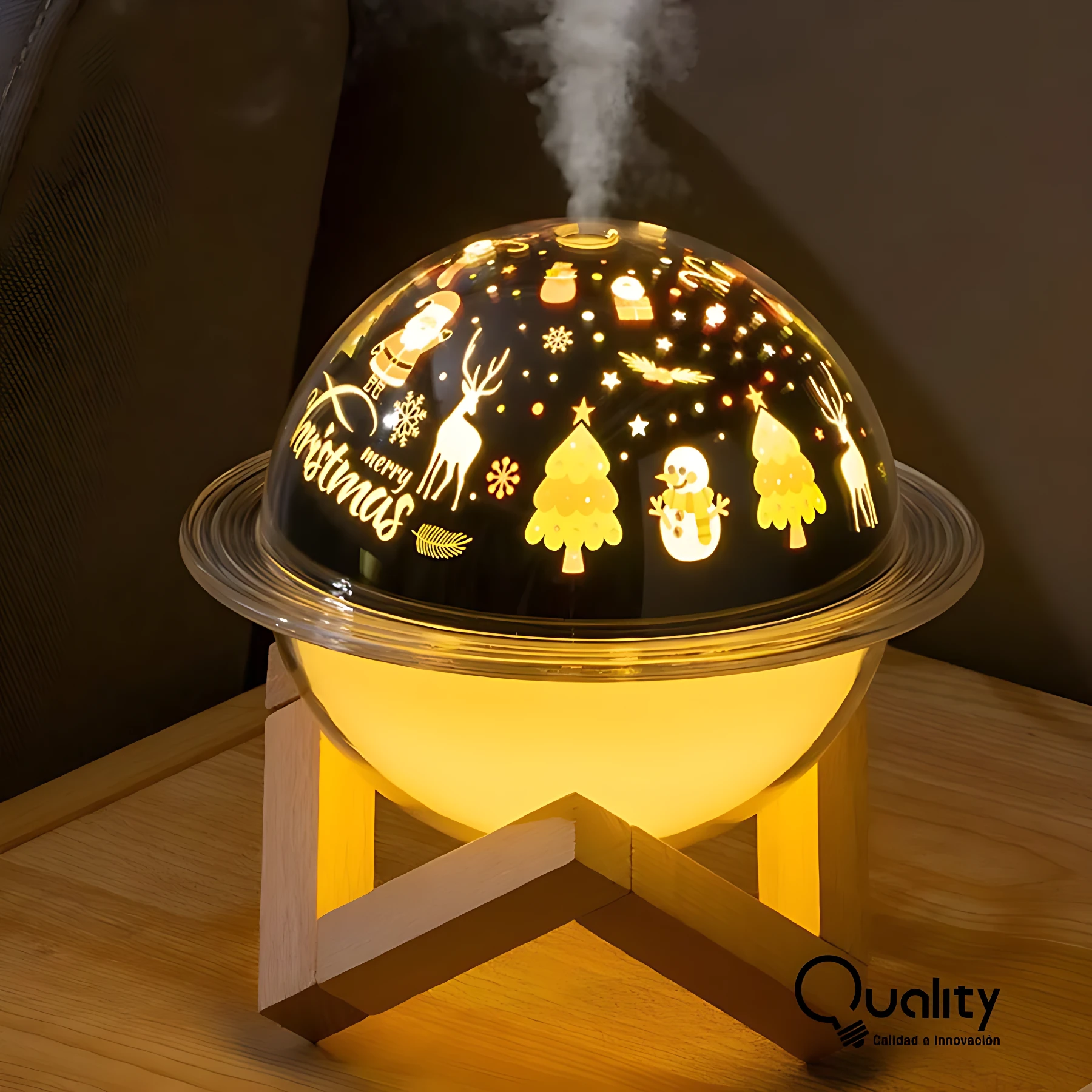Humificador lámpara esférica con proyección navideña: renos, árboles, muñeco de nieve y texto “Merry Christmas” en relieve sobre superficie negra translúcida, emitiendo luz cálida amarilla desde interior, montada sobre base de madera clara en forma de triángulo invertido, con vapor visible saliendo de la parte superior.
